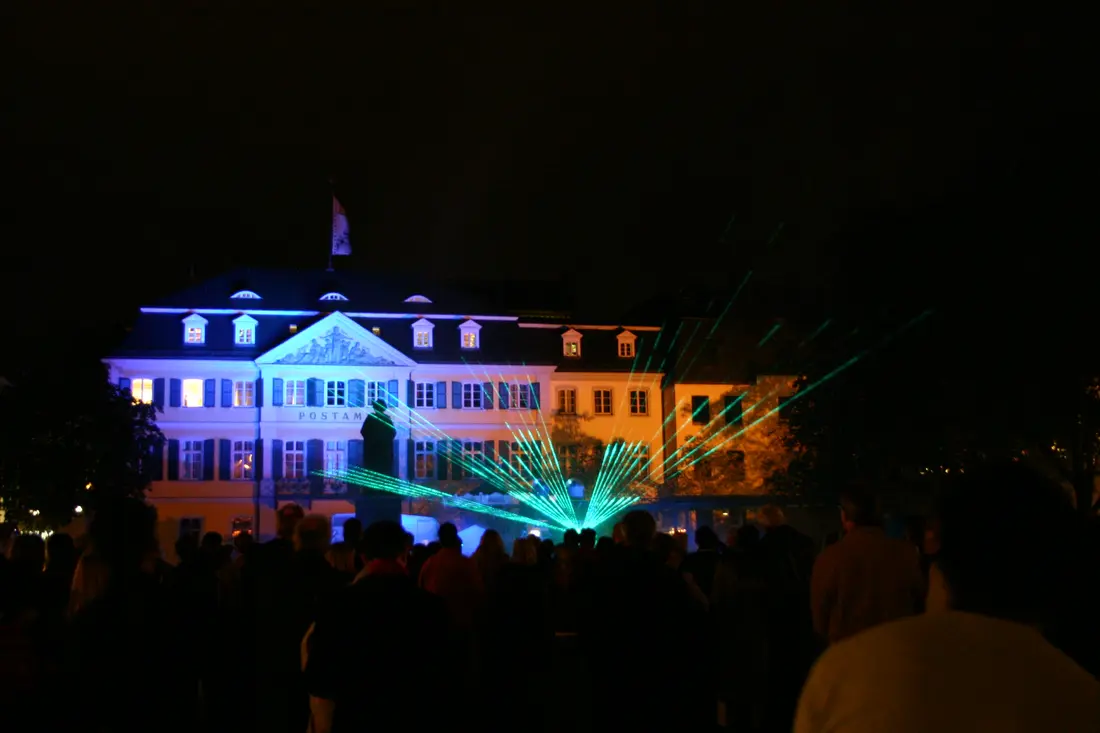 Gebäudeprojektion mit grünen Laserstrahlen bei Nacht