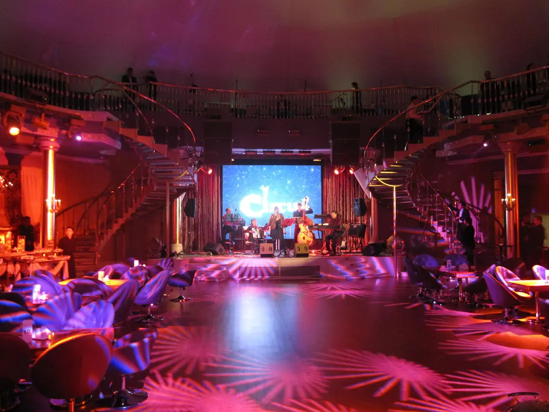 Clubbühne mit geschwungenen Treppen und Live-Band