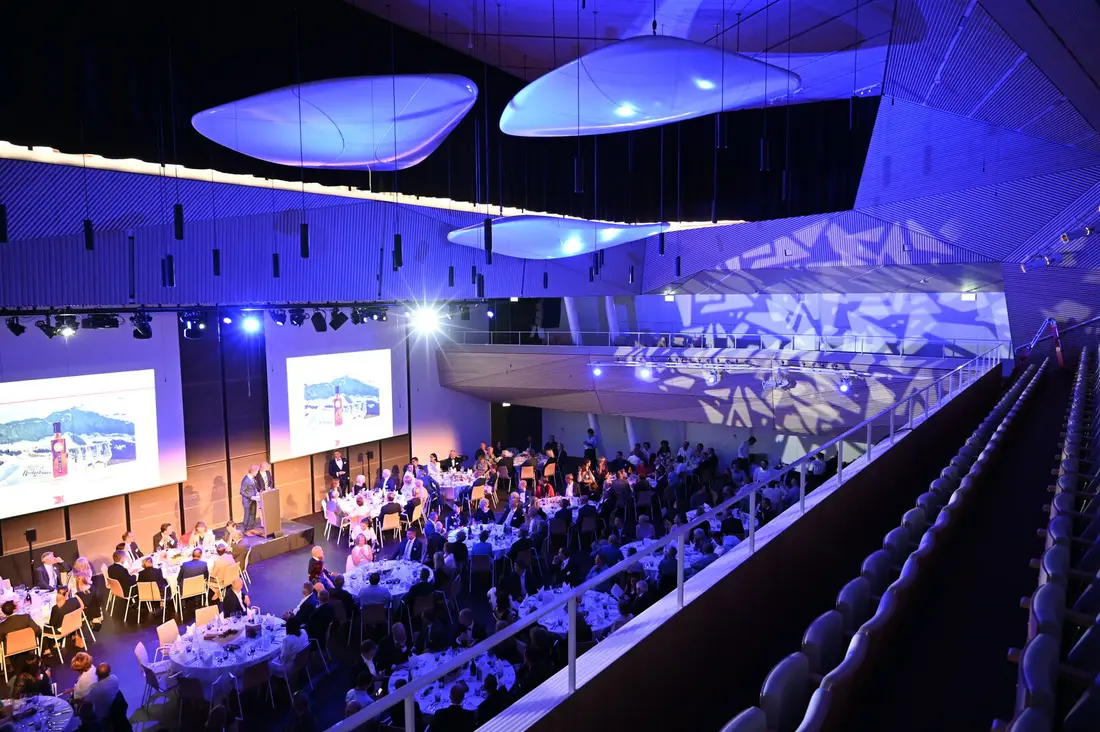 Moderner Ballsaal mit Bühne, Leinwänden und blauer Illumination