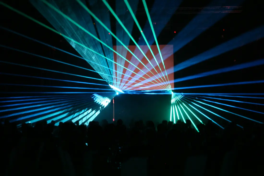 Grün-blaue Lasershow über einer Menschenmenge
