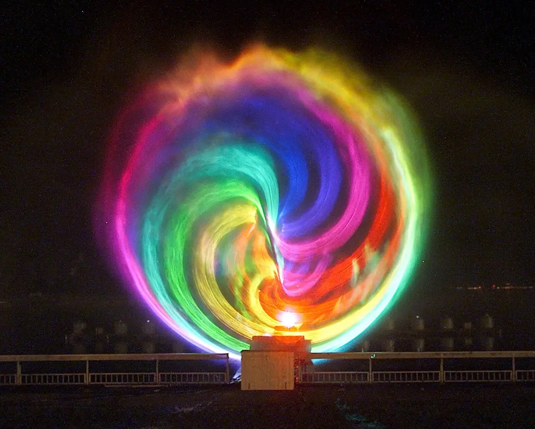Kreisförmige Lasershow in Regenbogenfarben über dem Wasser