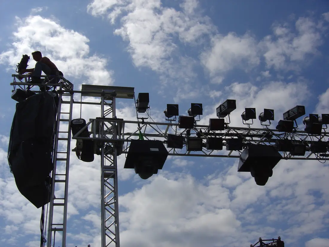 Techniker bei der Traversenmontage vor blauem Himmel